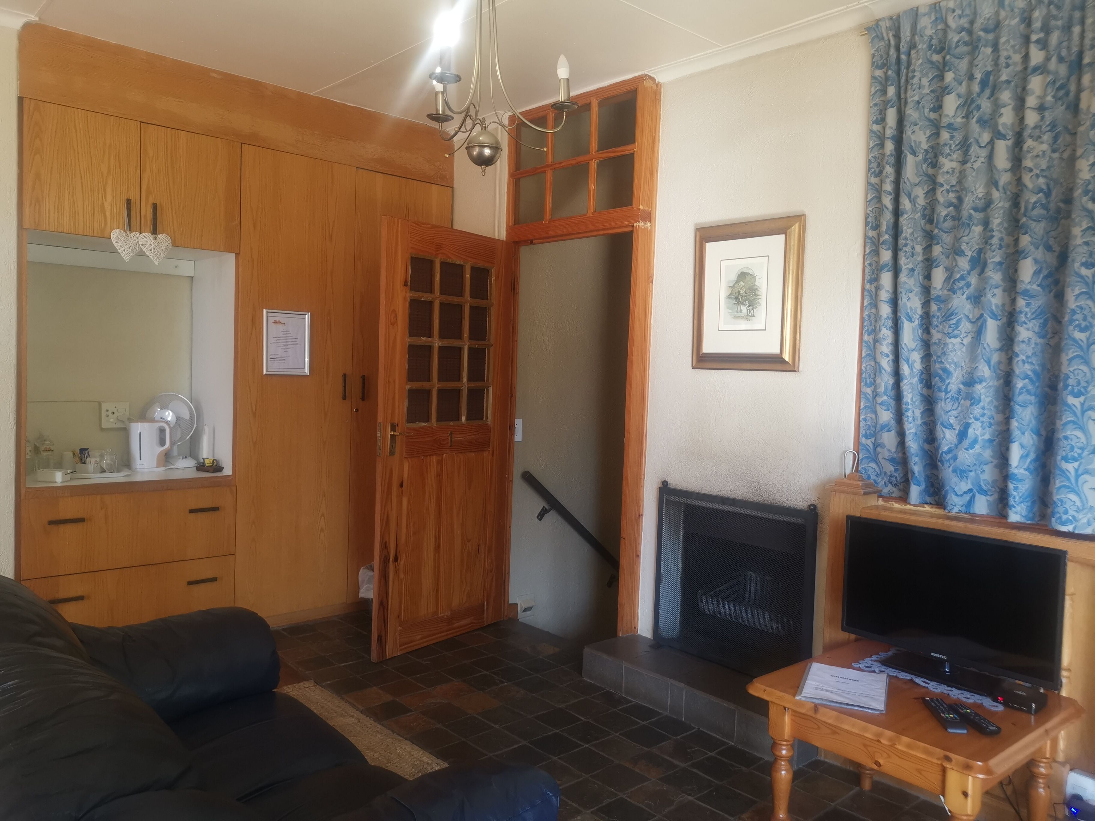 Una sala de estar con chimenea, televisor y sofá.