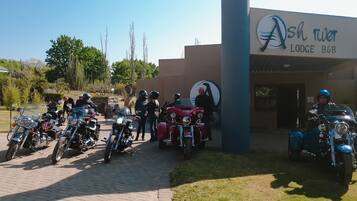 Un groupe de motos est stationné devant un bâtiment sur lequel on peut lire l’inscription : « Ash River Lodge, chambres d’hôtes ».