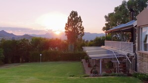 A house with a covered patio and a view of mountains. - Ash River Lodge B&B (Clarens)