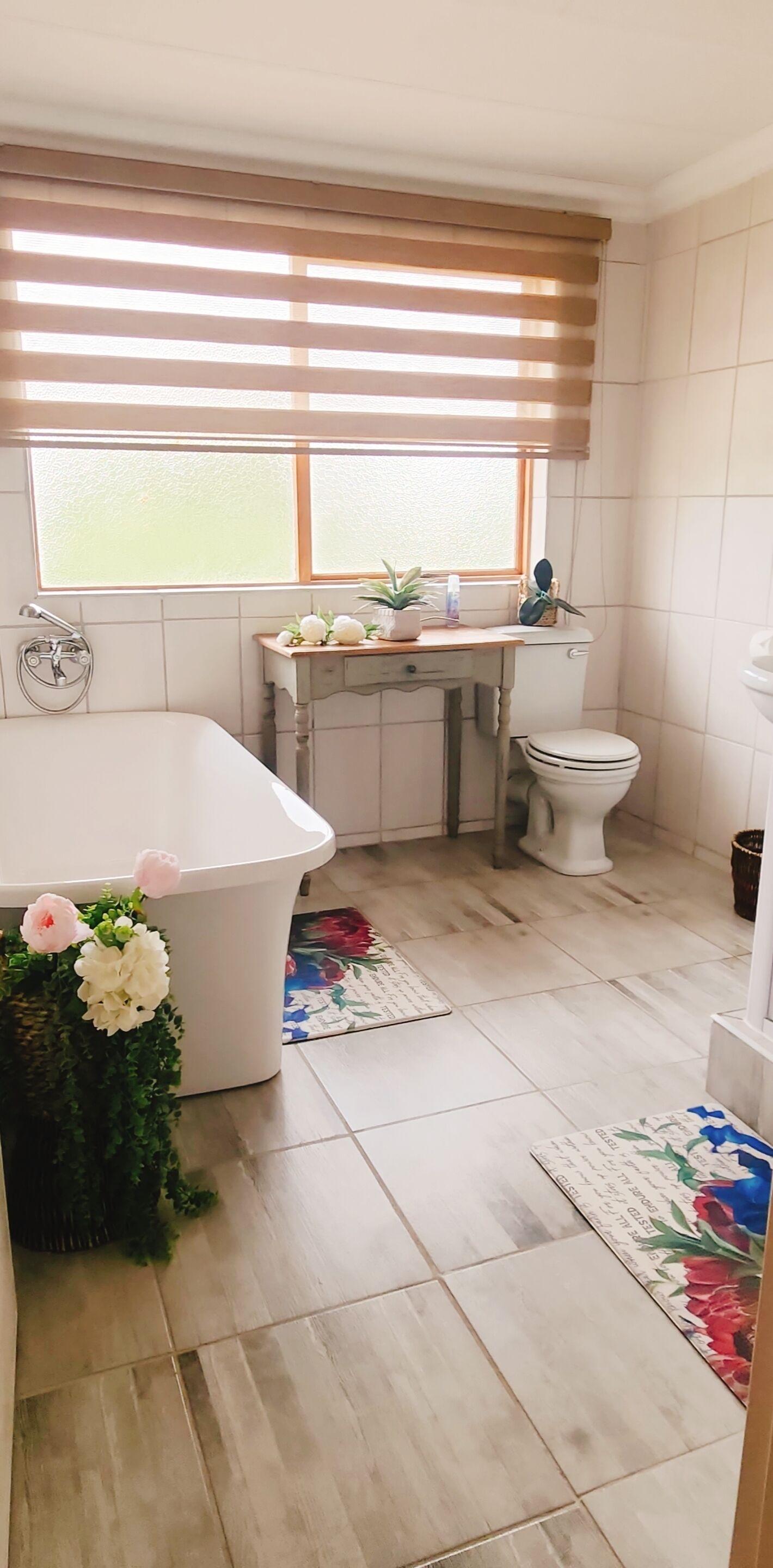 A bathroom with a bathtub, toilet, and window.