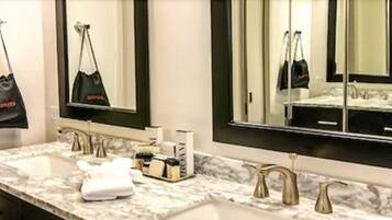 A bathroom with two sinks, a large mirror, and a towel rack.