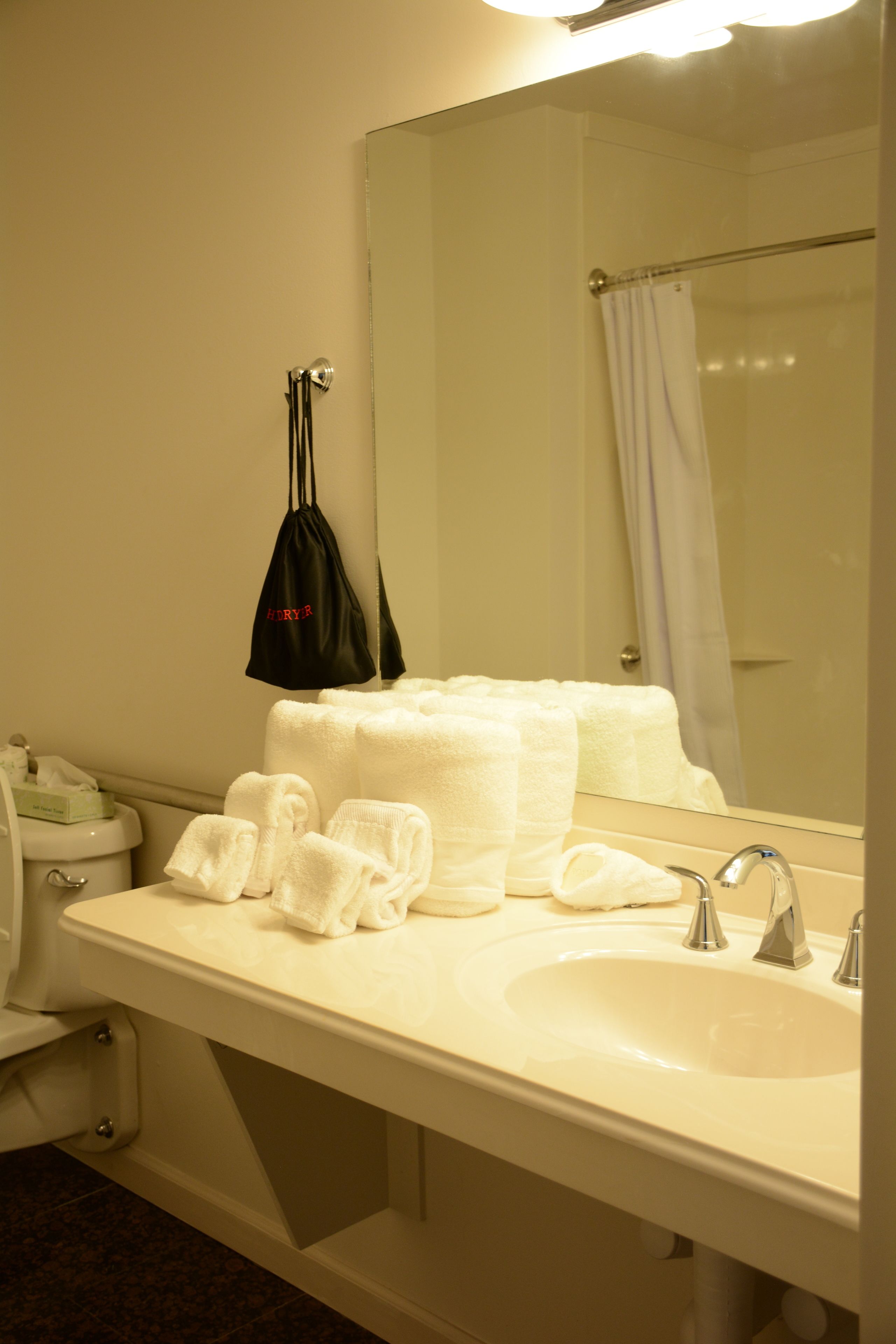 A bathroom with a sink, mirror, and towel rack.