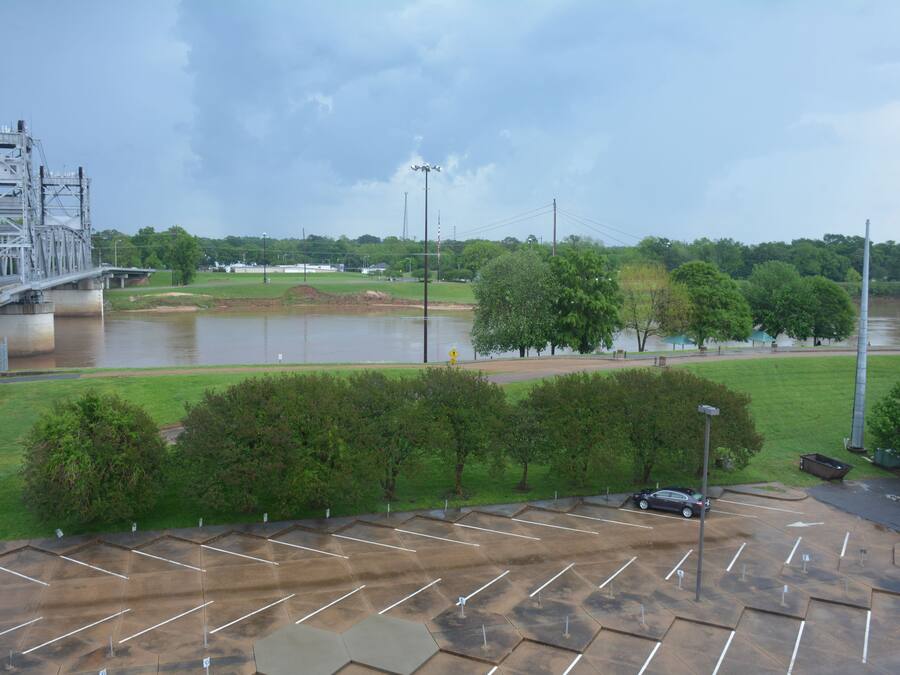 A parking lot with a bridge in the background.