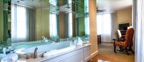 A modern bathroom with a large bathtub, a glass-enclosed shower, and a vanity with a mirror.