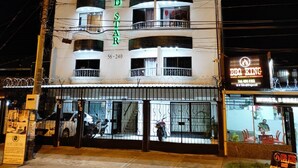 Un hotel a più piani con balconi e un cartello con la scritta 'HOTEL LORD STAR'.