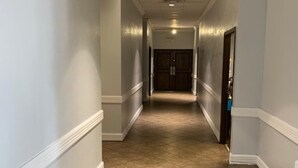 A corridor with beige tiled flooring, white walls, and a door at the end. - E-Z 8 Motel Phoenix Airporter (Phoenix)