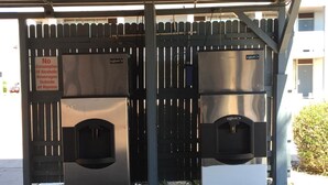 A public restroom with a no-alcohol consumption sign, two sinks, and a vending machine. - E-Z 8 Motel Phoenix Airporter (Phoenix)