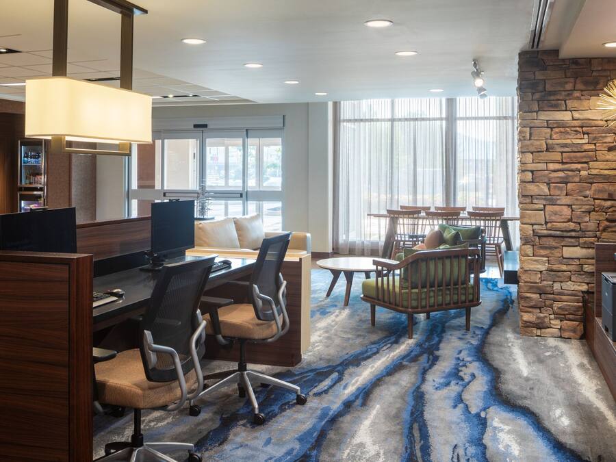 A hotel lobby with a reception desk, seating area, and a stone accent wall.