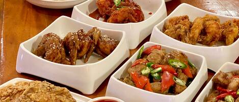 A variety of dishes in white bowls on a wooden table.