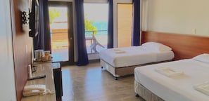 Habitación de hotel con dos camas, un escritorio y teléfono, y vistas al exterior.