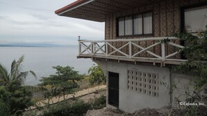 Een kustgebouw met een balkon dat uitkijkt over de zee, met een decoratieve buitenkant en een eenvoudig ontwerp.