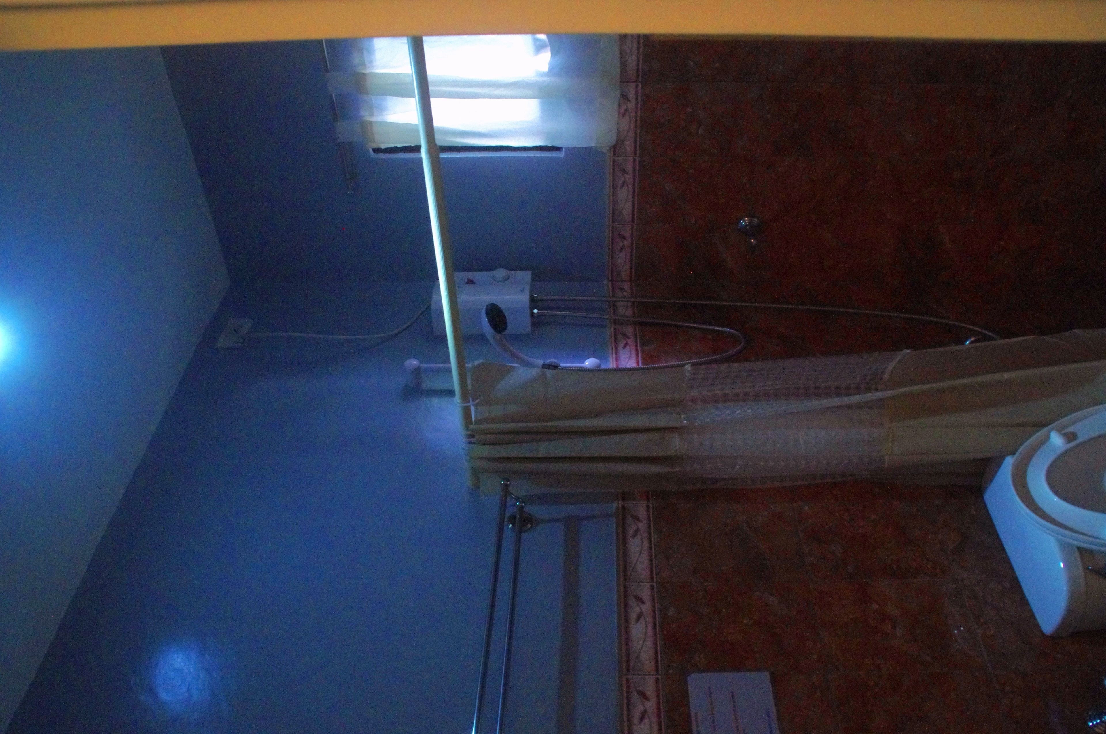 A bathroom with a toilet, a sink, and a mirror.