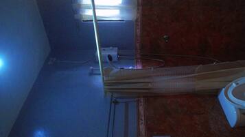 A bathroom with a toilet, a sink, and a mirror.