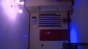 A hallway with a door, a fan, and a window with blinds. - Pedz Cing Mango Lodge (Oslob)