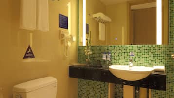 A bathroom with a toilet, sink, and mirror.