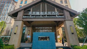 Un hotel con un letrero llamativo que dice "Mercure Hotel Nanchang Sunag".