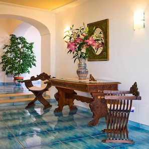 A dining area with a wooden table, chairs, and a vase with flowers.