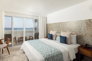 A hotel room with a large bed, a balcony with a view of the sea, and a patterned headboard. - Bamburi Beach Hotel (Mombasa)