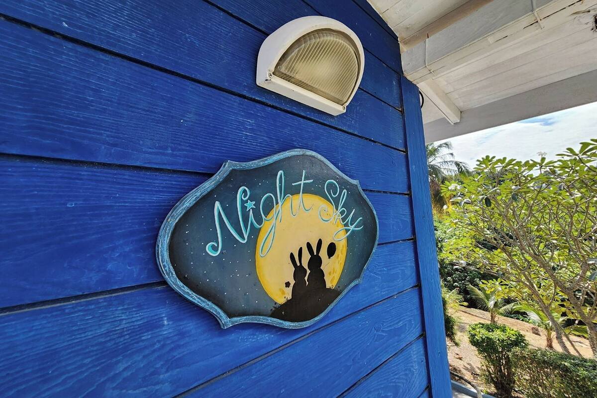 A blue building with a decorative sign that reads "Night Sky" and features a moon and two rabbits.