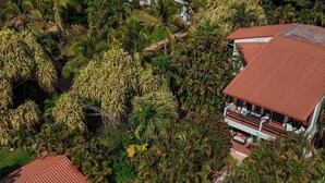 An aerial view of a resort with a swimming pool, lounge chairs, and lush greenery. - Hotel Villa Del Sol (Sardinal)