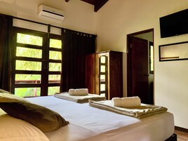 Una habitación de hotel con cama, armario y puerta que da al exterior.