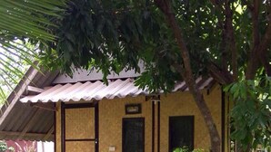A wooden deck with two chairs, a small table, and a sign above a door. - Banana House Pai (Pai)