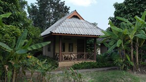 A small, single-story house with a corrugated metal roof and a porch. - Banana House Pai (Pai)