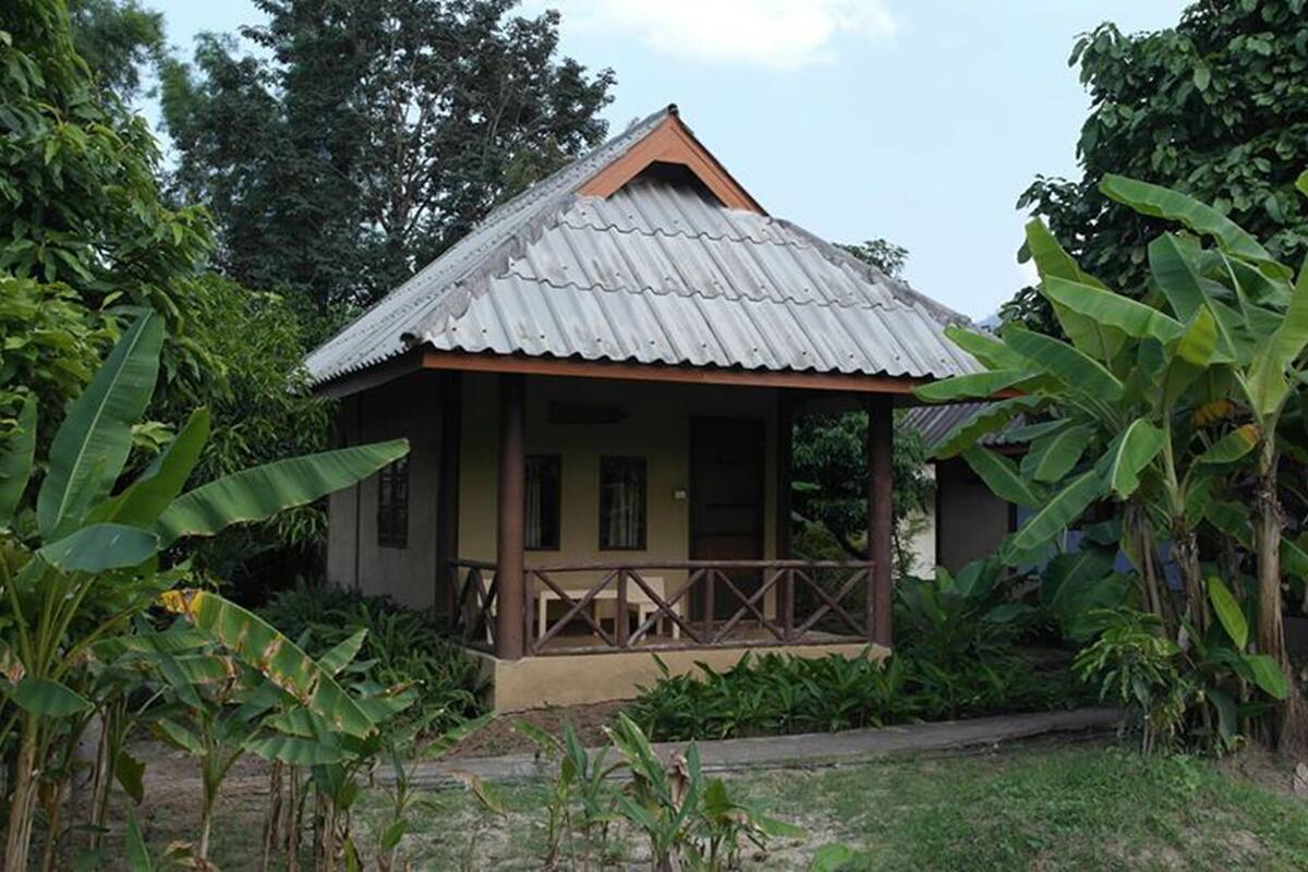 A small, single-story house with a corrugated metal roof and a porch.