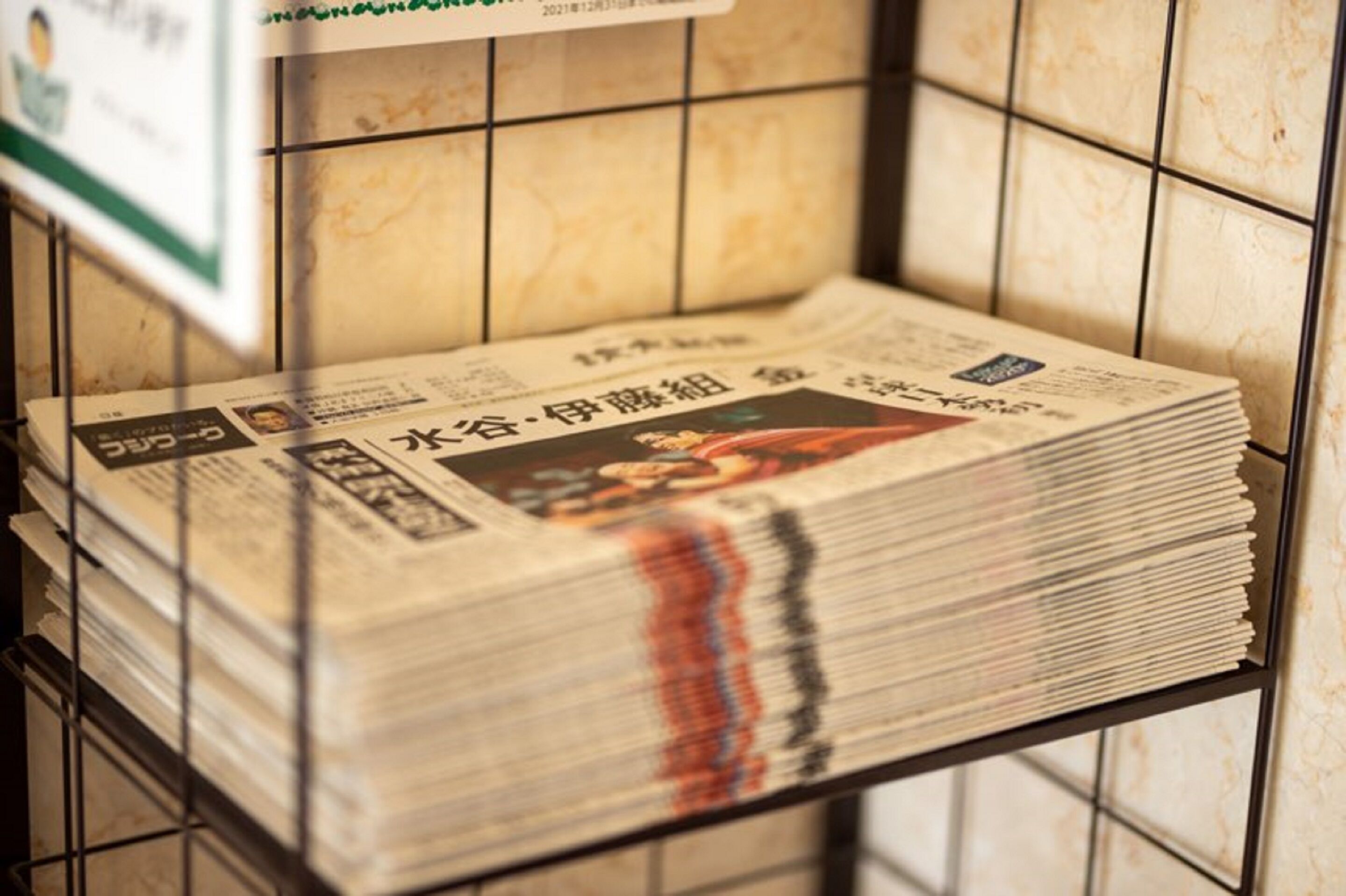 A stack of newspapers on a metal rack.