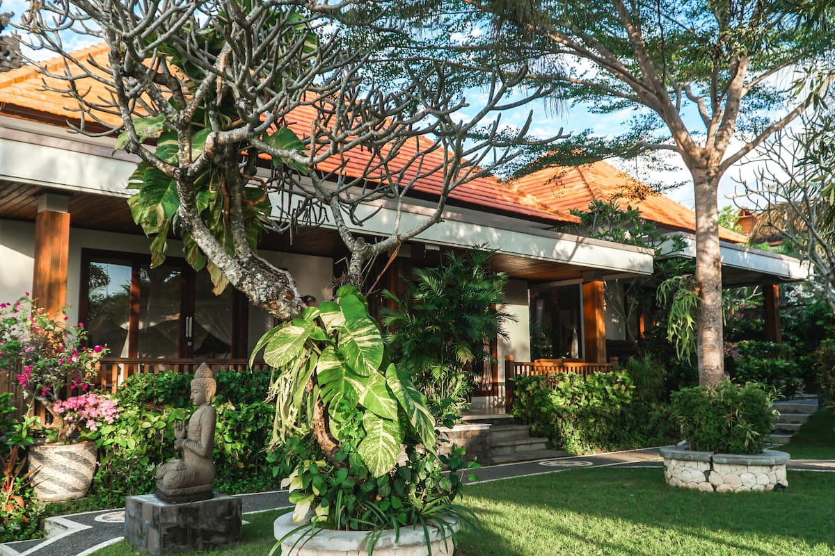 A modern house with a tiled roof, surrounded by lush greenery and a well-maintained garden.