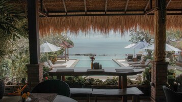 Una piscina al aire libre, sombrillas, sillones reclinables de piscina