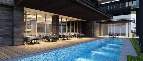 Una piscina con cubierta de madera, mobiliario exterior y un diseño arquitectónico moderno.