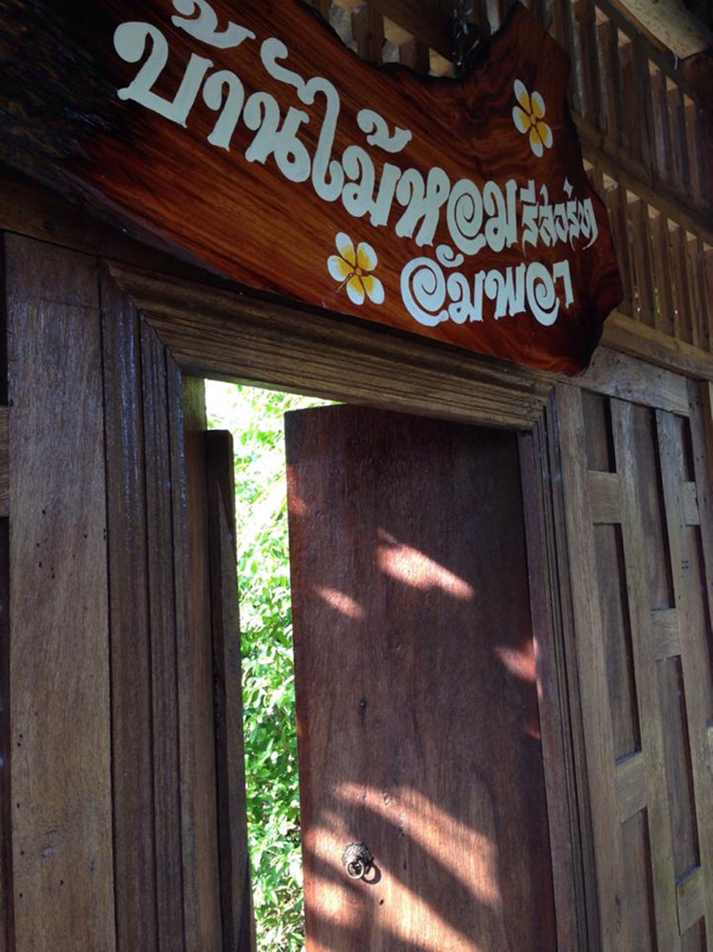 Una puerta de madera con un cartel arriba.