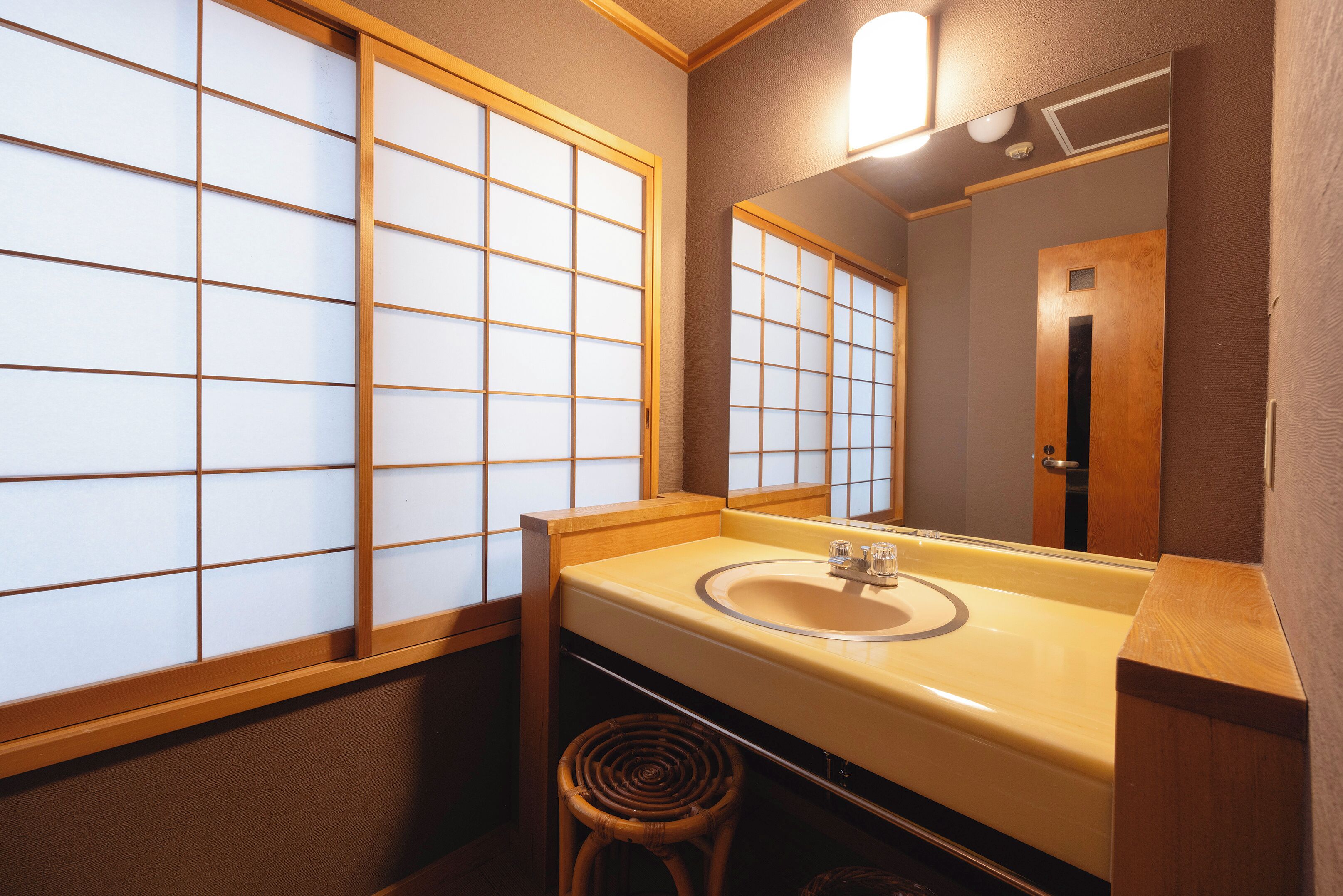 A bathroom with a wooden vanity, a sink, and a mirror.
