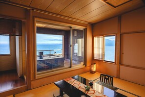 A room with a view of the sea, a wooden ceiling, and a table with a teapot and cup. - Inatori Toukai Hotel Yuen (Higashiizu)