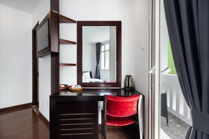 A compact room with a desk, a red chair, a flat-screen TV, a mirror, and a view of the outside balcony. -  A&A Toronto Hotel (Ho Chi Minh City)