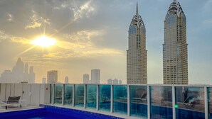 A rooftop pool with a city skyline in the background. - Naumi Hotel Dubai (Dubai)