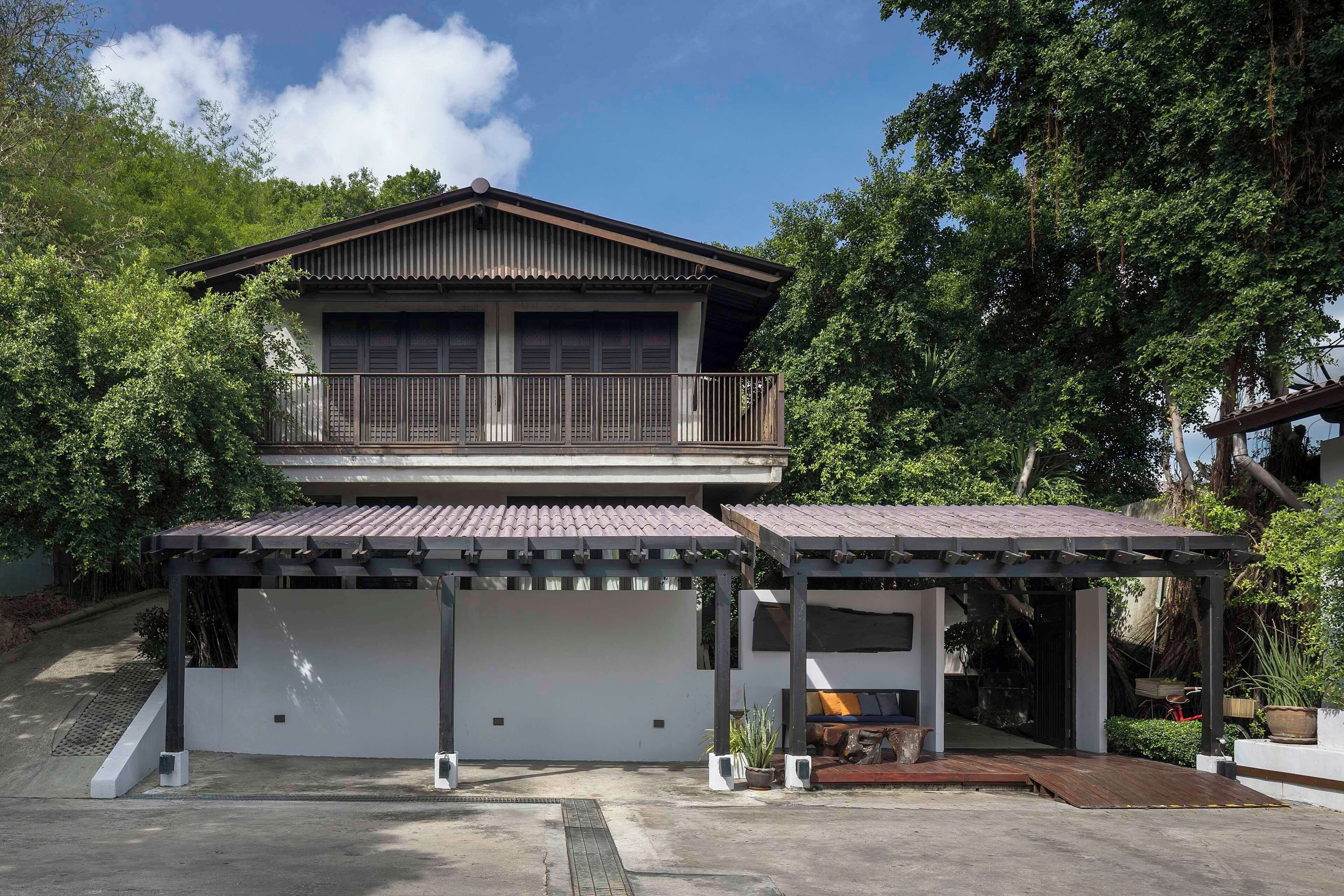 Ein zweistöckiges Haus mit Balkon, überdachter Veranda und Garage.