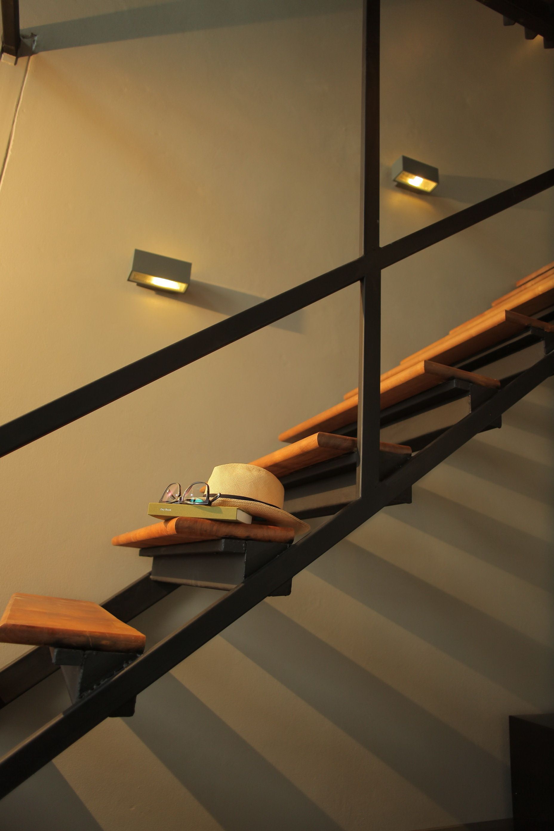 A modern staircase with wooden steps and black metal railings.