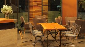 A modern dining area with a wooden table and chairs, large windows, and hanging pendant lights. - Space 59 Ratchaburi (Ratchaburi)