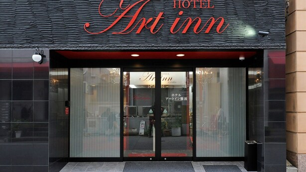 The exterior of a hotel named Art inn with a modern design, featuring a black facade and large glass doors. - Hotel Art Inn Namba (Osaka)