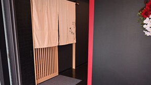 A room with a dark wall, a wooden cabinet, and a red accent wall. - Hotel Art Inn Namba (Osaka)