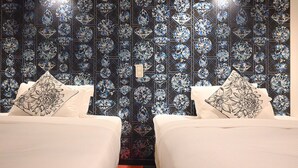 A hotel room with two beds, each with a floral-patterned pillow, and a wall decorated with a diamond pattern. - Hotel Art Inn Namba (Osaka)