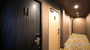 A hotel hallway with a patterned carpet, a door labeled "501", and a wall-mounted elevator control panel. - Hotel Art Inn Namba (Osaka)