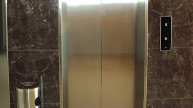A modern elevator with a metallic finish and a control panel on the wall. - GM City Hotel (Klang)