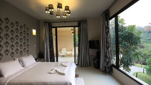 A hotel room with a large bed, a chandelier, a TV, and a view of the outdoors. - Hi - Scene Resort (Suan Phueng)