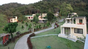 A hillside residential area with modern houses, a winding driveway, and well-maintained gardens. - Hi - Scene Resort (Suan Phueng)