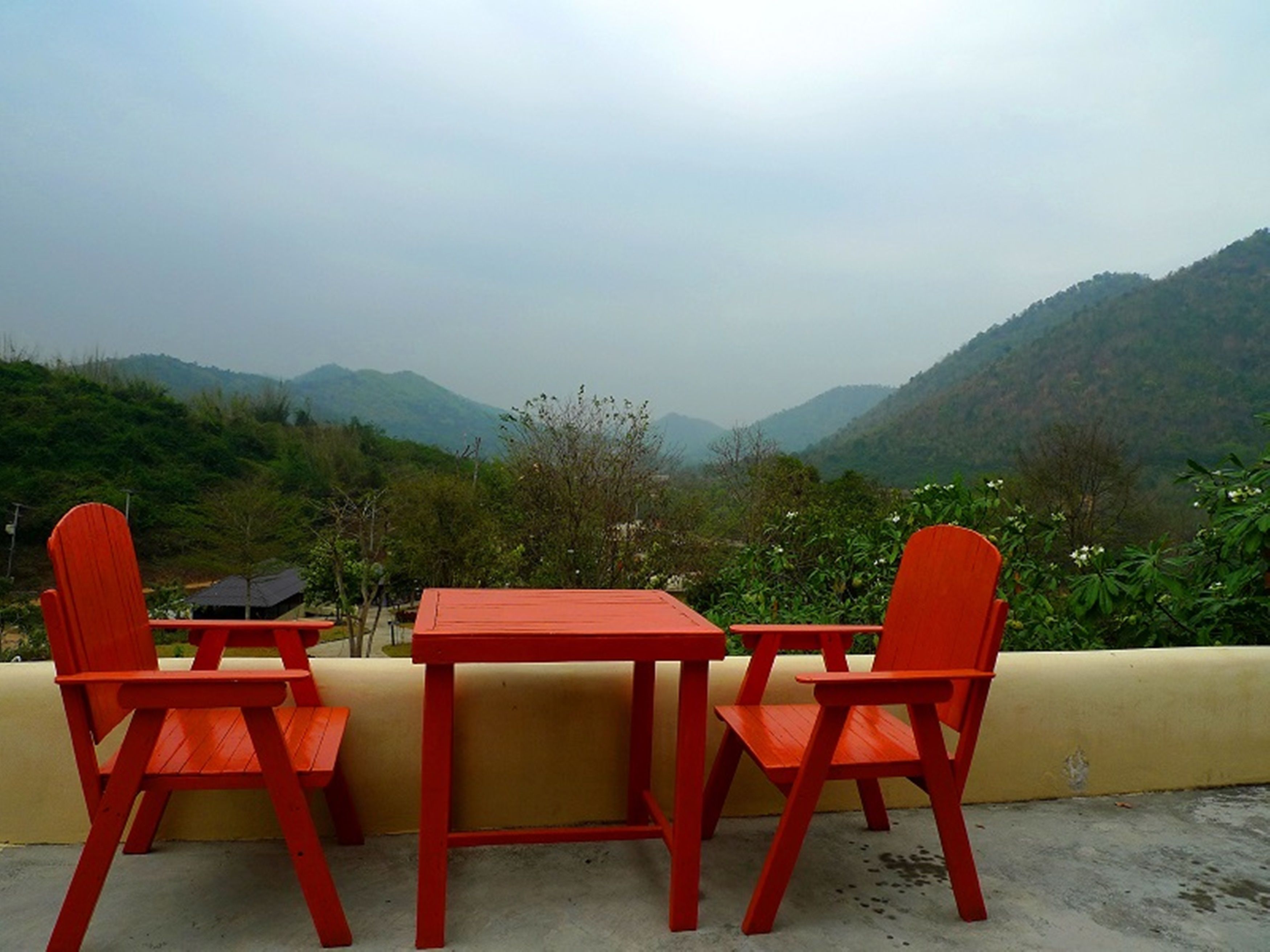 Une table et deux chaises avec vue sur un paysage montagneux.