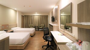 Une chambre d’hôtel avec deux lits, un bureau, une chaise, une télévision et un grand miroir.