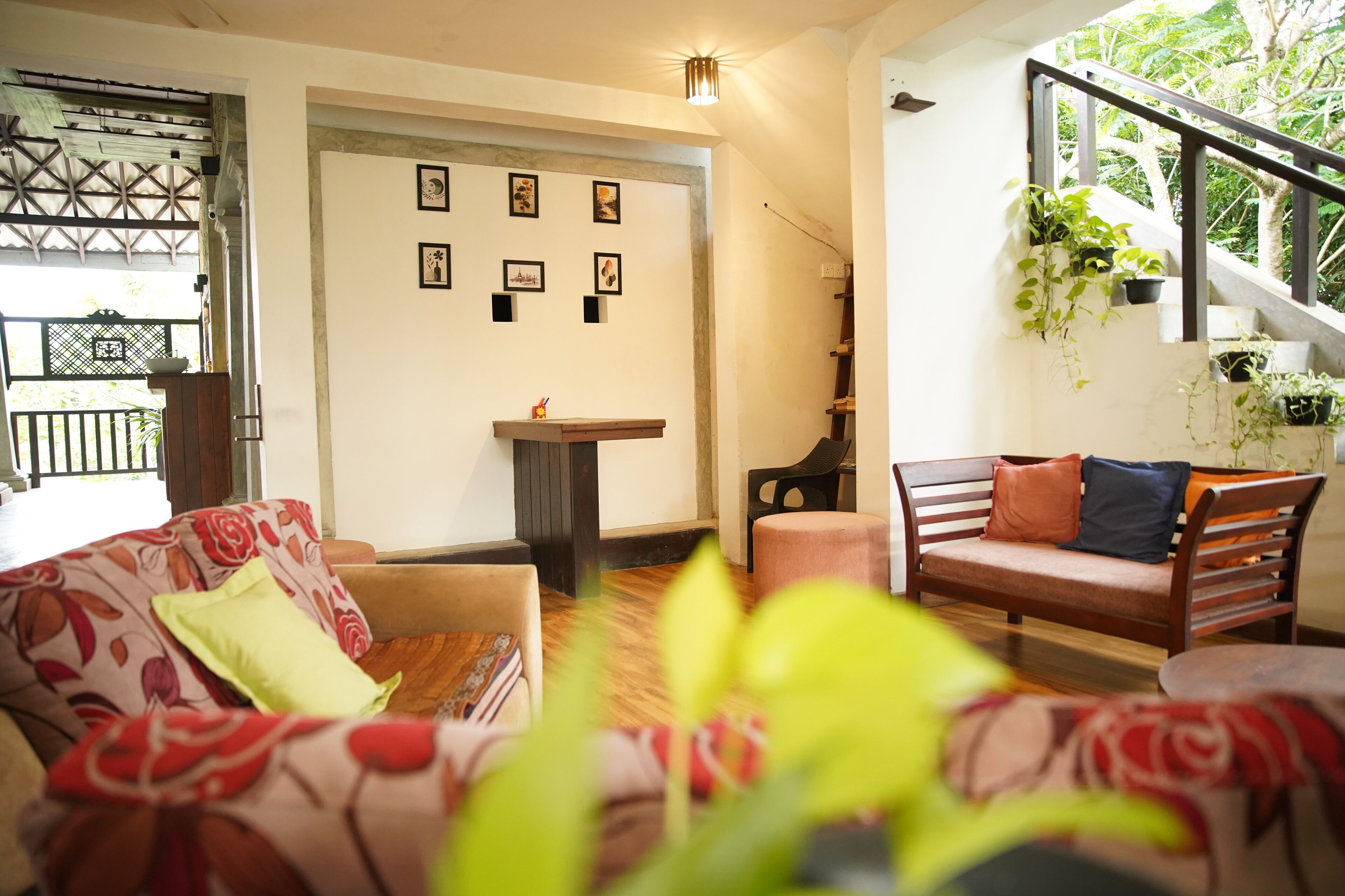 A living room with a sofa, a coffee table, and a staircase with plants.